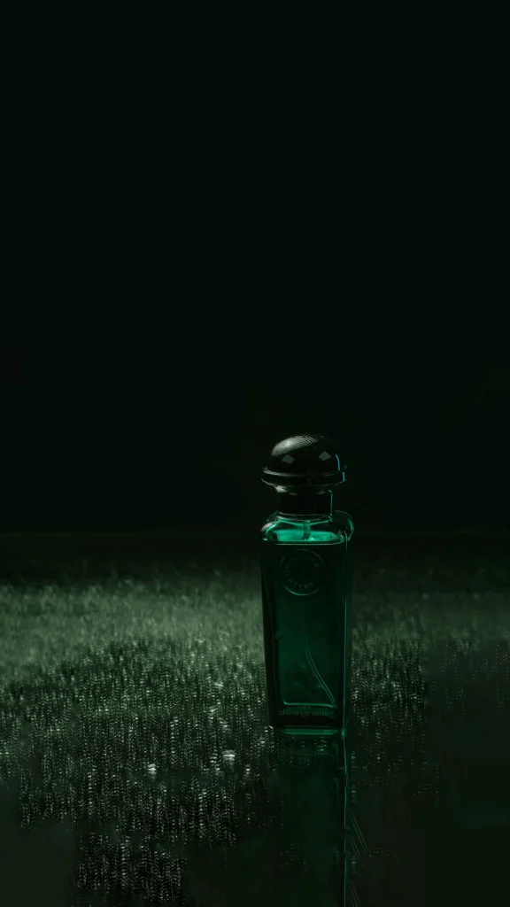 Flacone di profumo verde su superficie di vetro riflettente, atmosfera scura ed elegante