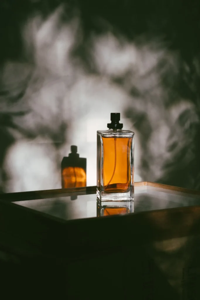 Flacone di profumo fotografato in primo piano su sfondo neutro